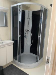 a shower with a glass enclosure in a bathroom at Slinningen Apartment with free parking in Ålesund