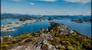 a group of people walking on top of a mountain at Slinningen Apartment with free parking in Ålesund