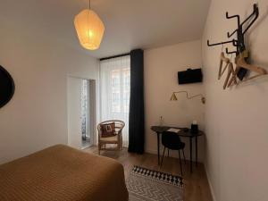 Schlafzimmer mit einem Bett, einem Tisch und einem Fenster in der Unterkunft Hôtel du Commerce in Cluny