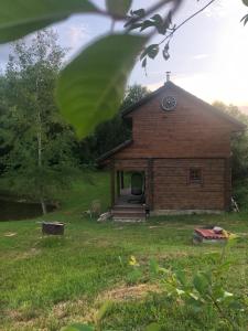 a building in a field with a grassy yard at Liepų pirtis in Smailiai