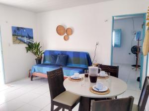 uma sala de estar com uma mesa e um sofá azul em Casinha Estrela do Mar o Oceano aos seus Pés em Aracati