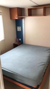 a bedroom with a large bed with a blue mattress at Mobil Home in Siouville