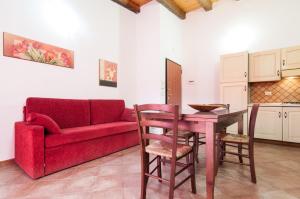 a living room with a red couch and a table at Le Case Al Quadrato in Siracusa