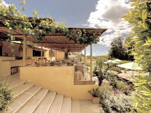 a patio with a pergola and tables and chairs at Toile Blanche in Saint-Paul-de-Vence