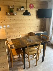 a dining room with a wooden table and chairs at APPARTEMENT PIED DES PISTES-ALPE D'HUEZ-LES BERGERS-1 Chambre-5 personnes in L'Alpe-d'Huez