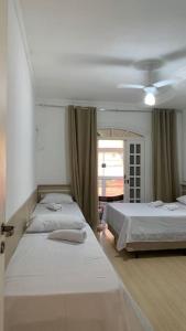 a bedroom with two beds and a window at Casa de Maria in Aparecida