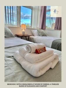 - une chambre d'hôtel avec 2 lits et des serviettes dans l'établissement St Martins House Long Stay Offers, à Roundhay