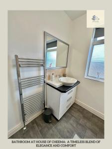 La salle de bains est pourvue d'un lavabo et d'un miroir. dans l'établissement St Martins House Long Stay Offers, à Roundhay