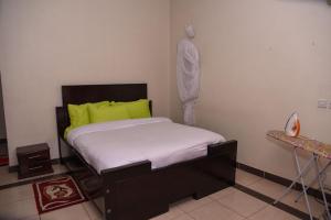 una piccola camera da letto con un letto con un cuscino verde di Keys to Paradise Sapphire 5 Nextgen a Nairobi
