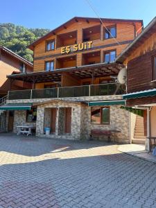 Un edificio con un banco delante de él. en EŞ Pansiyon, en Uzungöl 143 fotos más