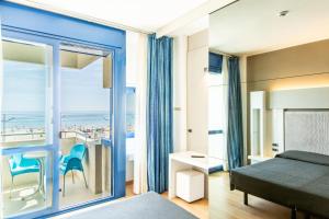 um quarto com uma cama e vista para o oceano em Hotel Baltic Riccione-Fronte Mare em Riccione