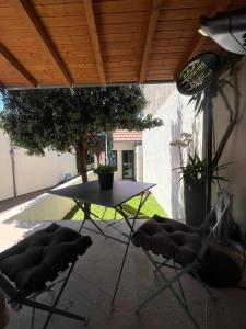 a patio with a table and chairs under a roof at JM Alojamento local no Porto in Porto