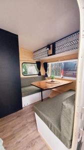 a tiny house with a table and a couch at La Cour d'Hortense in Sailly-Flibeaucourt