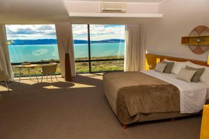 a bedroom with a large bed and a large window at Design Suites Calafate in El Calafate