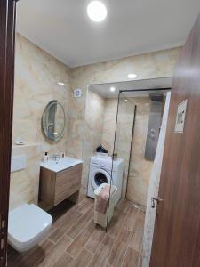 a bathroom with a toilet sink and a washing machine at Infinity Apartment in Nea Moudania +35 photos