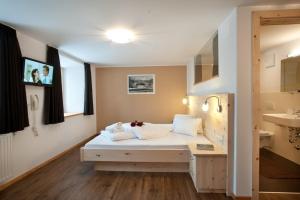 a small room with a bed and a sink at Hotel Hofer in San Valentino alla Muta