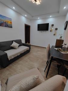 a living room with a couch and a table at Infinity Apartment in Nea Moudania
