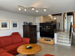 a living room with a red couch and a television at Ferienhaus Andrea mit Whirlpool und Sauna in Rimsting