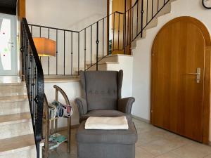 a living room with a chair and a staircase at Ferienhaus Andrea mit Whirlpool und Sauna in Rimsting