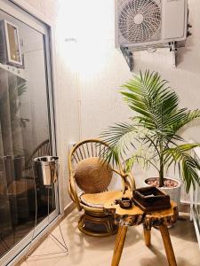 une chambre avec une chaise et une table avec une plante dans l'établissement The Prime Escape Town House, à Arusha