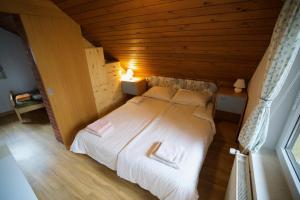 sypialnia z dużym łóżkiem w drewnianym pokoju w obiekcie Apartma Gracner w Bledzie
