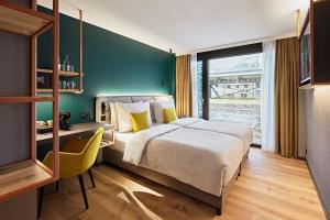 sypialnia z dużym łóżkiem i zieloną ścianą w obiekcie Essential by Dorint Interlaken - New Opening w mieście Interlaken