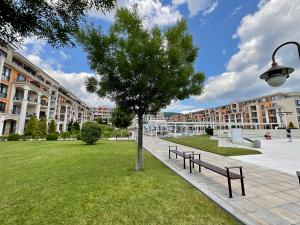 a park with benches and a tree in front of a building at Apartment Premier Fort Beach hotel F1 420 in Sveti Vlas