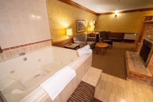 Best Western Fireside Inn في كينغستون: غرفة في الفندق مع حوض استحمام وغرفة معيشة