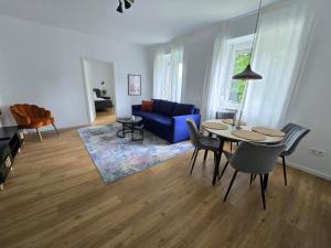 uma sala de estar com uma mesa e um sofá azul em Central stylish apartment em Braunau am Inn