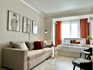 a living room with a bed and a couch at Студия ДЭНДИ с видом на горы in Almaty