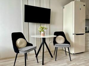 a dining room table with two chairs and a white table with a table at Студия ДЭНДИ с видом на горы in Almaty