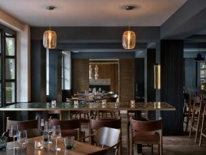 ein Restaurant mit einer großen Bar mit Tischen und Stühlen in der Unterkunft Kimpton Virgilio Polanco by IHG in Mexiko-Stadt