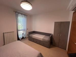 a bedroom with a bed and a cabinet and a window at Casa Antia, nuovo bilocale con giardino in Residence con piscina in Numana +43 photos