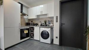 a kitchen with a washing machine and a washer at Orchidea apartman in Balatonalmádi