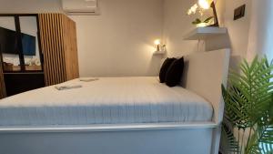 a bedroom with a white bed in a room at Orchidea apartman in Balatonalmádi