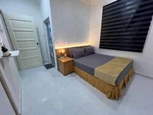 a small bedroom with a bed and a window at Kak Pah Homestay Paka in Kampong Baru