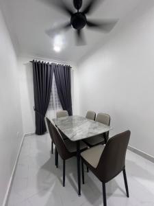 a dining room with a table and chairs and a ceiling fan at Kak Pah Homestay Paka in Kampong Baru