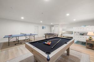 a living room with a pool table and two tables at Pickleball~ Pool~ Game Room~ 5 min to Beach in Seminole