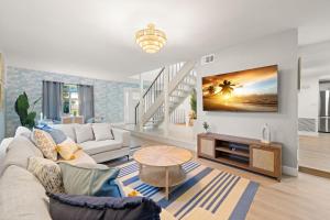 a living room with a couch and a tv at Pickleball~ Pool~ Game Room~ 5 min to Beach in Seminole