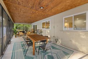a patio with a wooden table and chairs at Pickleball~ Pool~ Game Room~ 5 min to Beach in Seminole +46 photos