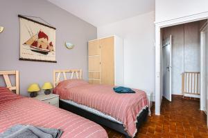 a bedroom with two beds and a cabinet at Gite les Cigognes in Marennes +18 photos