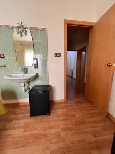 Un baño con un lavabo y un espejo en la pared. en Pensión Laforja, en Barcelona