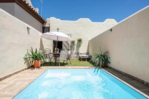una piscina en un patio trasero con sombrilla en Casa Dorca, 2, en Conil de la Frontera