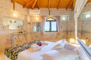 a bedroom with a large bed in a stone wall at Paco's Resort Luxury Villa 18 in Oziás +12 photos