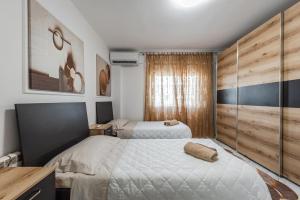 a bedroom with two beds and a wooden wall at Magic Sea View in Durrës