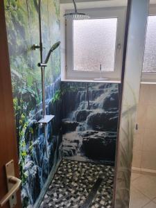y baño con ducha y una pintura en la pared. en Ferienwohnung Markert, en Bad Staffelstein