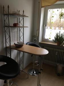 Una mesa y dos taburetes en una habitación con ventana. en Ferienwohnung Markert, en Bad Staffelstein