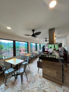 een keuken en eetkamer met tafels, stoelen en ramen bij CLH Suites Ilha Grande in Abraão