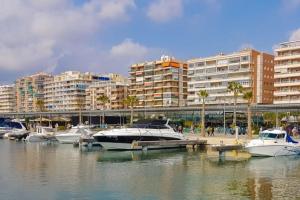 un grupo de barcos atracados en un puerto deportivo con edificios en Cozy apartment beach 300 metros, en Santa Pola