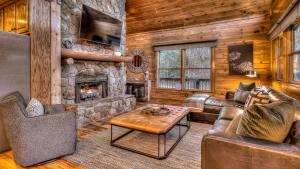 a living room with a stone fireplace in a cabin at Tranquility Ranch in Mineral Bluff